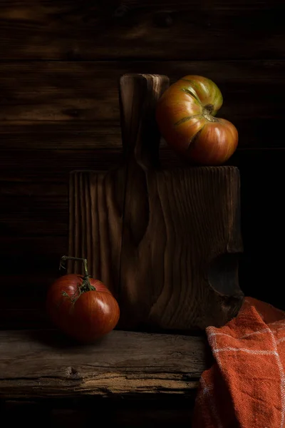 暗い木製の背景に木製のプレートに新鮮なトマト トマトの収穫 鍵が低い — ストック写真