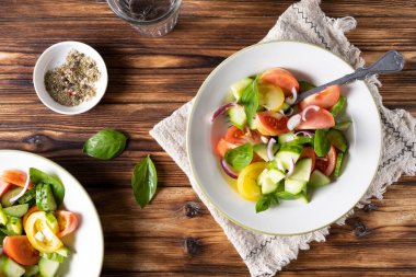 Tahta masadaki beyaz kasede taze yeşil salata. Kırsal biçim.