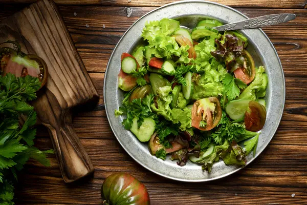 Salad hijau segar dalam mangkuk logam di atas meja kayu. Gaya Rustik. — Stok Foto