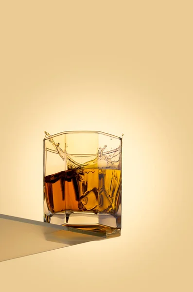 Ice cube spetteren in scotch op witte achtergrond — Stockfoto