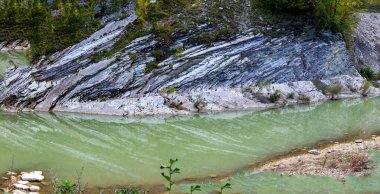 Dağ nehri sonbahar mevsiminde kayalık sahillerin taş yatağında..