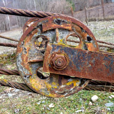 Eski paslı çelik bir kablo parçası, özel bir klips ve kaldırma işlemleri için blok ile korunuyor..