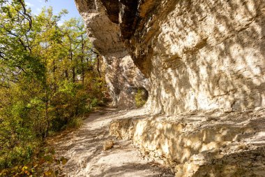 Sonbahar doğası, sıcak bir sonbahar gününde, zorlu bir yol boyunca bir dağ kanyonu boyunca yürür..
