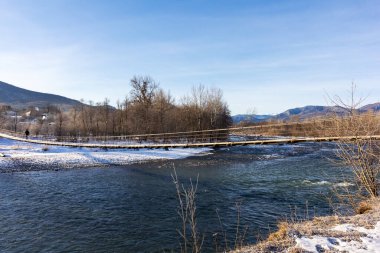 Dağ eteklerinde kış, buzsuz bir nehir, dondurucu bir sabah, yükselen güneşin ışınlarında..