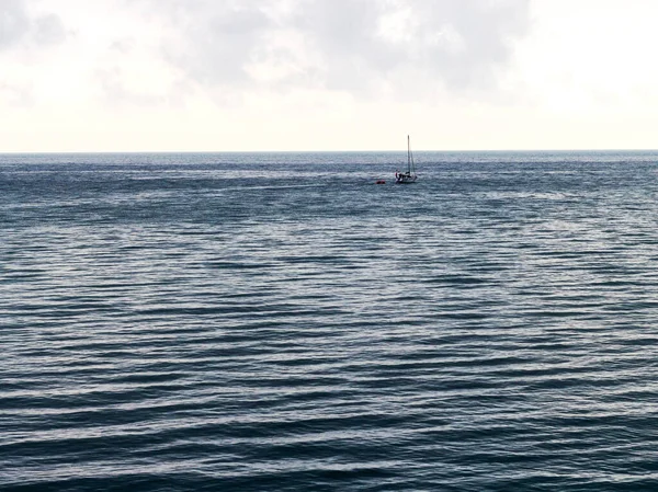 A yacht going on a small sea trip, in cloudy weather and a slight sea disturbance.