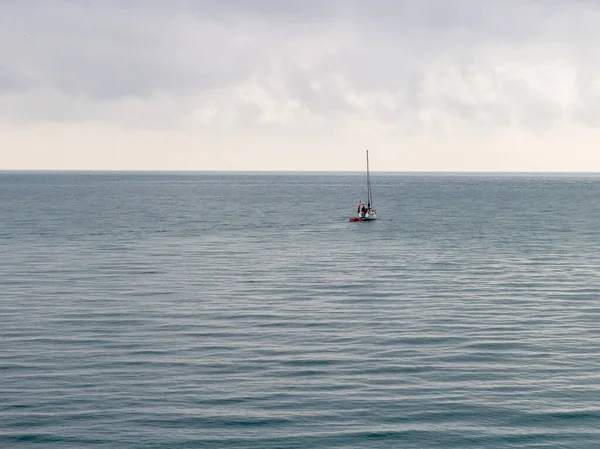 A yacht going on a small sea trip, in cloudy weather and a slight sea disturbance.