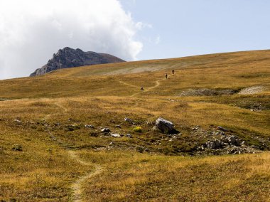 Sıcak, güneşli bir sonbahar gününde dağların dağlık alandaki yürüyüş patikalarından doğayla yürüme ve iletişim kurma panoramik manzarası..