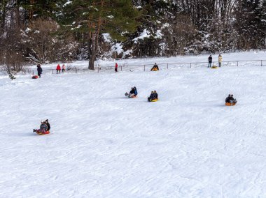 Maykop, Adygea Cumhuriyeti, Rusya Federasyonu, 01. - 24. 2021: Dağlarda aile tatili, dondurucu kış sabahı, kar motosikleti ve şişme kızak, yeni yıl tatili.