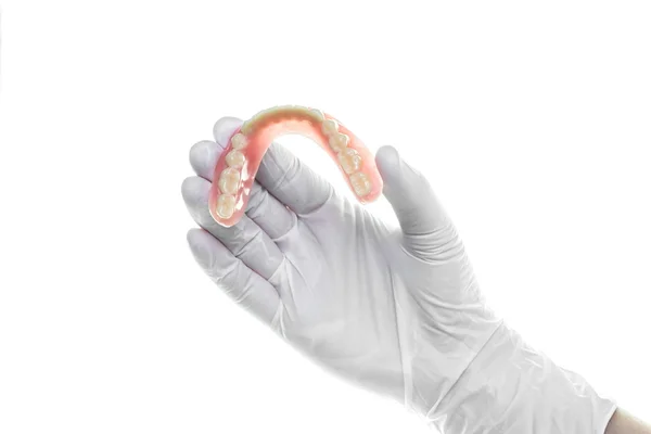 Dentadura na mão sobre fundo branco — Fotografia de Stock