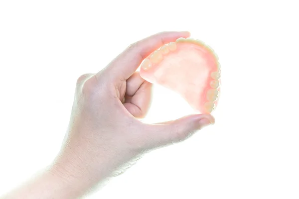Зубний протез в руці на білому тлі — стокове фото