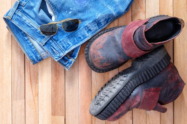 Jeans und Stiefel, Fliegersonnenbrille auf Holzdeckel — Stockfoto