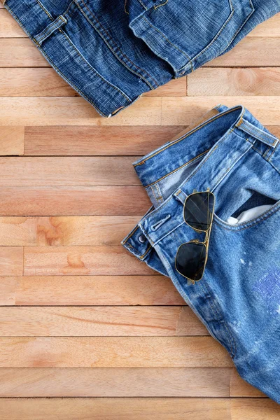 Jeans usados y gafas de sol Aviator encima de madera —  Fotos de Stock