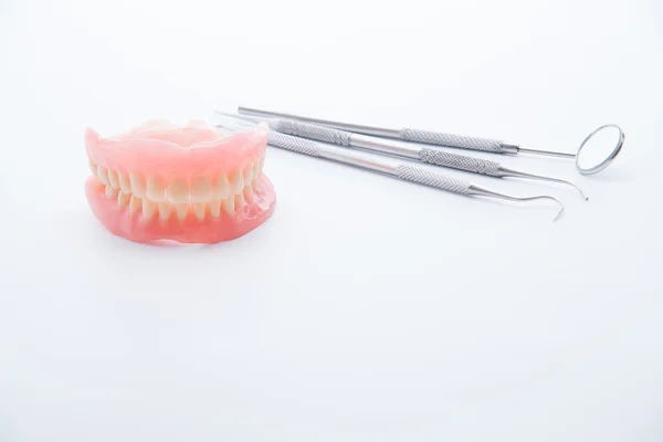 Denture and dental tools,dental mirror on white background — Stock Photo, Image