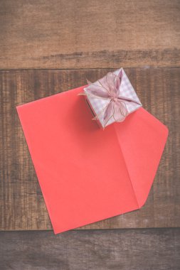 ahşap arka plan üzerinde hediye kutusu ve kırmızı zarf