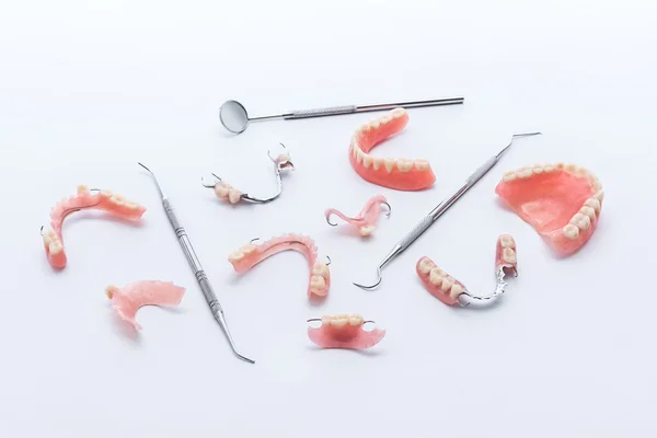 Conjunto de dentaduras e ferramentas odontológicas sobre fundo branco — Fotografia de Stock