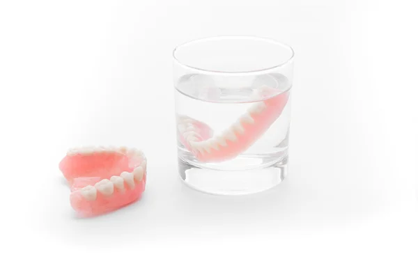 Teljes fogsor pohár vízben fehér háttér — Stock Fotó