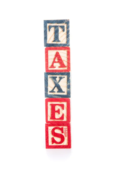 Foto van een alfabet blokken spelling belastingen op witte backg isoleren — Stockfoto