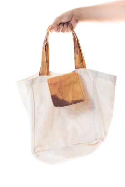 Χέρι που κρατά βαμβάκι τσάντα grunge σε άσπρο φόντο — Φωτογραφία Αρχείου