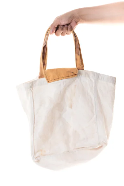Χέρι που κρατά βαμβάκι τσάντα grunge σε άσπρο φόντο — Φωτογραφία Αρχείου