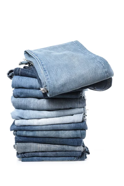 Куча джинсов на белом фоне — стоковое фото
