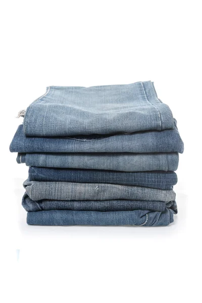 Pila di jeans su sfondo bianco — Foto Stock