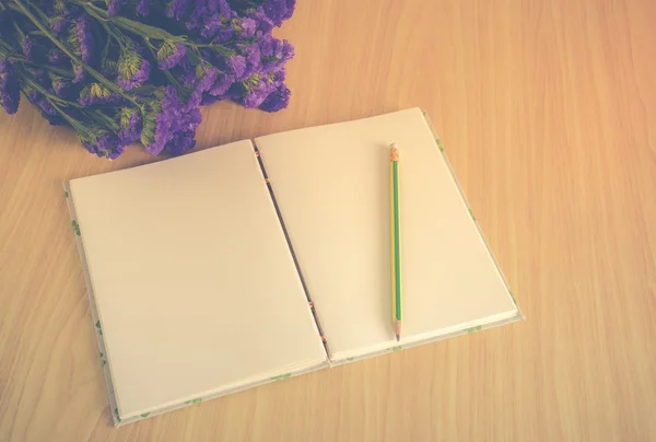 Libro fatto a mano con matita e fiore di Statice su tavola di legno — Foto Stock