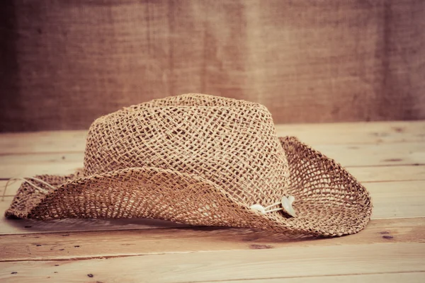 Cappello vintage su pavimento in legno grunge con tessuto di sacco backgr — Foto Stock