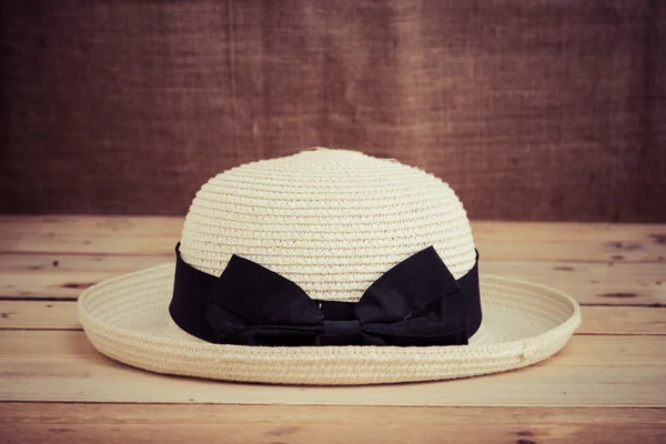 Cappello vintage su pavimento in legno grunge con tessuto di sacco backgr — Foto Stock