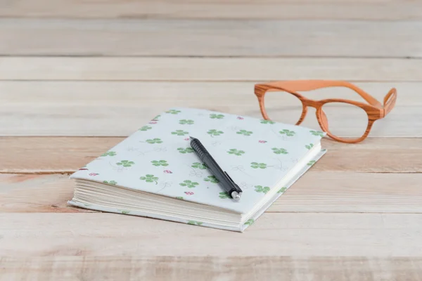 Libro y pluma, gafas en mesa de madera — Foto de Stock