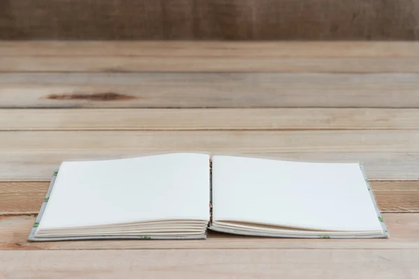 Libro abierto con páginas en blanco sobre tabla de madera —  Fotos de Stock