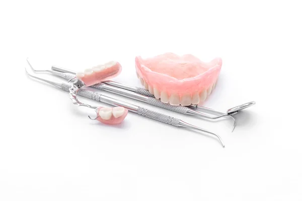 Prótesis y herramientas dentales, espejo dental sobre fondo blanco — Foto de Stock