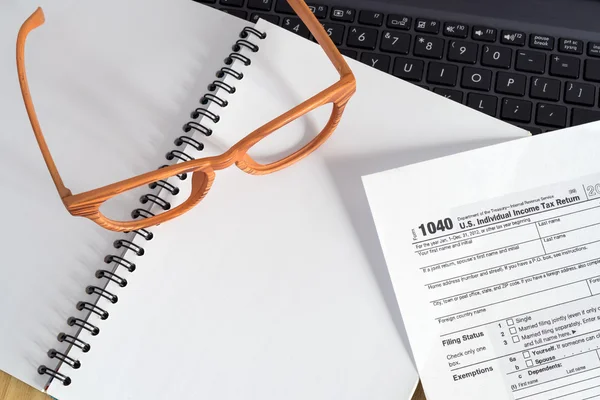 Mesa de mesa de escritório com computador portátil, óculos, 1040 taxform — Fotografia de Stock