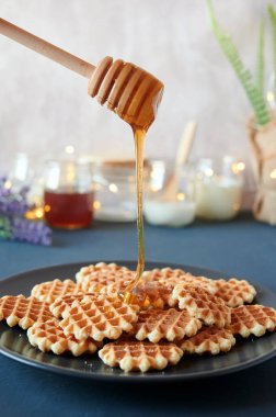Bir tabak taze waffle 'ın üzerine bal döküyorum.