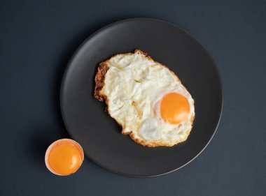 Siyah plakalı sahanda yumurta ve kırsal bir arka plan.