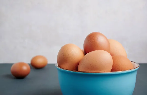 Kopya alanı olan mavi bir kasede taze yumurtalar.