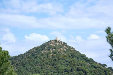 Dağın tepesinde bir şatosu olan manzara.