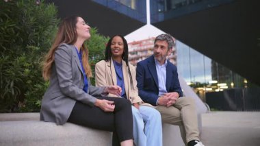 Modern bir şehrin finans bölgesinde bir arada duran ve konuşan üç çok kültürlü meslektaşım
