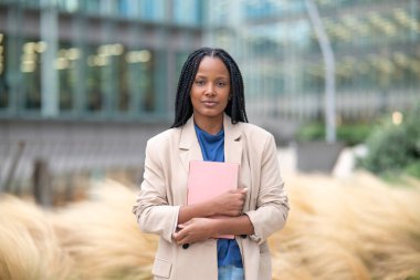 Şehir merkezinde elinde tablet olan siyahi bir iş kadını.