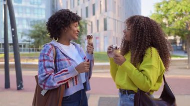 Afrika kökenli Amerikalı arkadaşlar şehirde birlikte dondurma yiyorlar.