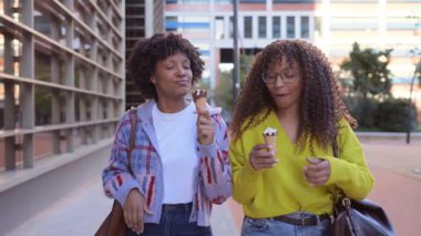 Afrikalı Amerikalı bayan arkadaşlar dondurma yiyorlar.