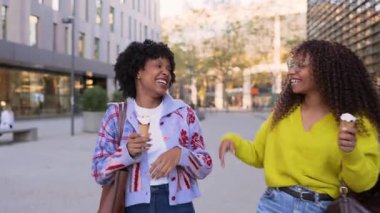 Afrikalı Amerikalı bayan arkadaşlar gülüyor ve beşlik çakıyor.