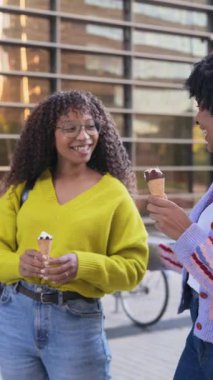 Açık havada dondurma yiyen mutlu Afrikalı Amerikalı kadınlar.