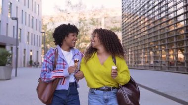 Yürüyen ve dondurma yiyen iki mutlu zenci kadın.