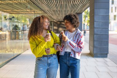 Mutlu kadınlar gülümsüyor ve dışarıda dondurma yiyor.