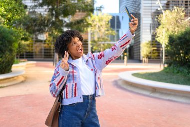 Genç kadın barış işareti göstererek selfie çekiyor.
