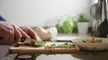 Sağlıklı bir yemek için yeşil fasulye kesen kişi.