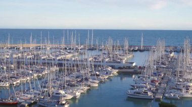 Katalonya 'da demirlemiş yelkenli ve yatlarla dolu Port Ginesta marinasının güneşli hava manzarası
