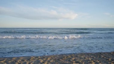 Gün batımında dalgaları bekleyen sörfçüler