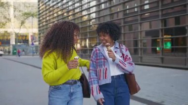 Açık havada dondurma yiyen mutlu Afrikalı Amerikalı kadınlar.