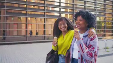 Siyah arkadaşlar yürüyor ve dondurma yiyorlar.